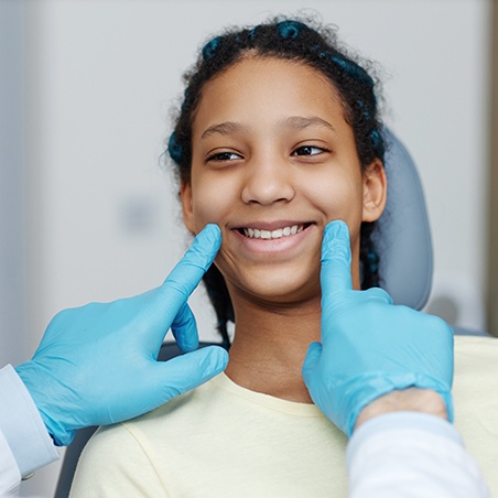 Dentist checking patient’s facial symmetry during appointment