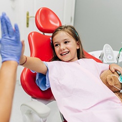 a child patient giving her dentist a high-five