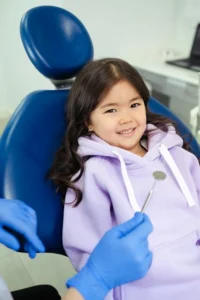 Smiling young girl in dentist’s chair